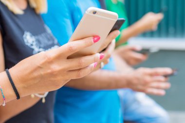 Bir grup arkadaş akıllı cep telefonu izliyor.