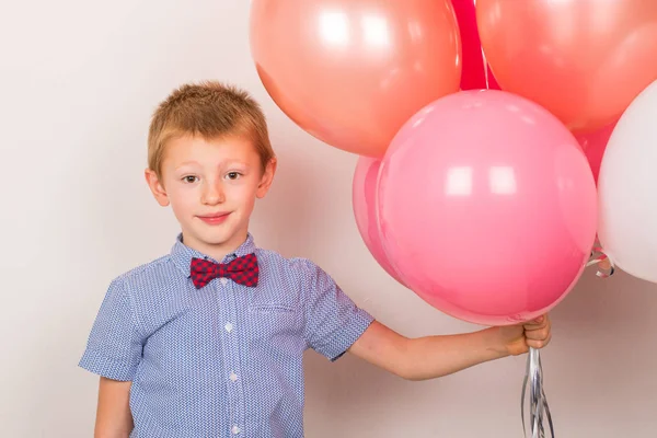 Ung leende pojke med rosa luft ballong — Stockfoto