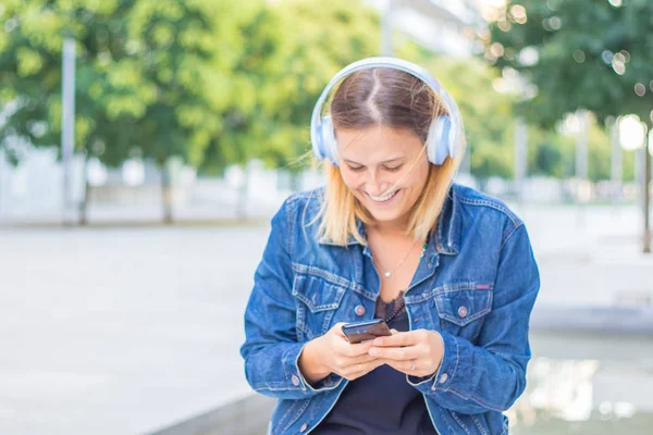 Young smiling woman is listen music with headphone — Stock Photo, Image