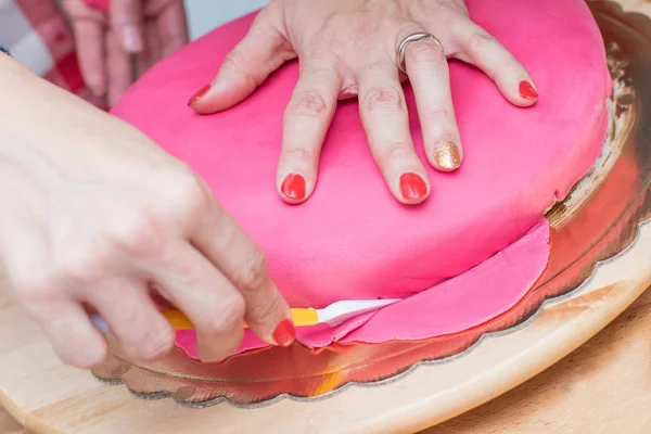 Женщин, готовящих и украшающих торт сахарной пастой — стоковое фото
