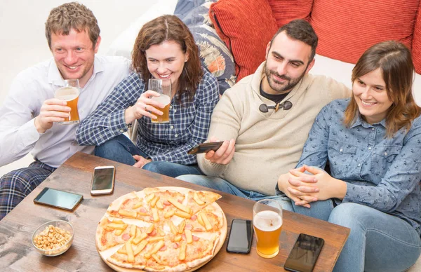 Group of friends are drinking beer, eating pizza, talking and sm — Stock Photo, Image