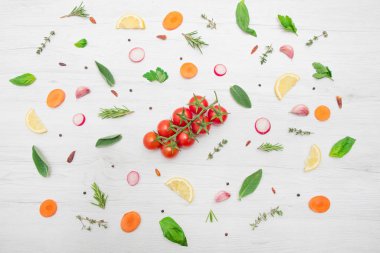 Çeşitli aromatik bitki yapraklarının üst görüntüsü ve ahşap arka planda kesilmiş sebzeler