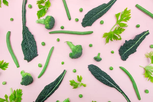 Draufsicht auf frisches grünes Gemüse auf rosa Hintergrund — Stockfoto