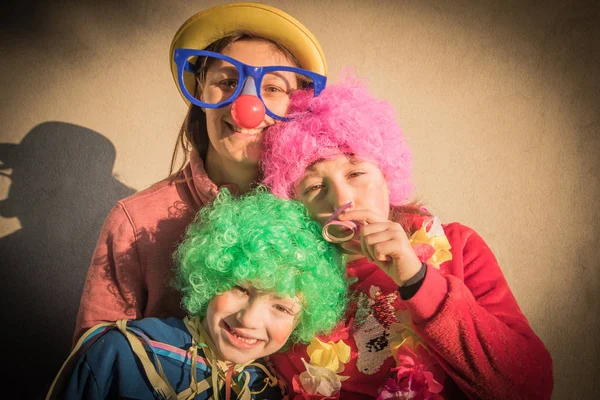 Moeder en kinderen in carnaval masker glimlachen samen buiten — Stockfoto