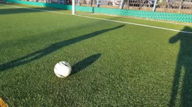 Genç çocuk sahada futbol antrenmanı yapıyor.