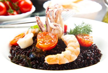 Dilimlenmiş mürekkep balığı, karides ve domatesli siyah pirinç.