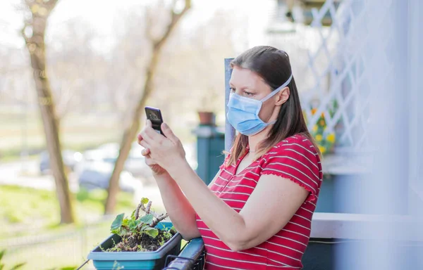 Mujer Caucásica Con Máscara Mirando Terraza Del Hogar Utilizando Teléfono — Foto de Stock