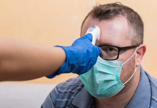 Coronavirus Krankenschwester Trägt Handschuhe Und Hält Medizinisches Infrarot Stirnthermometer Die Stockfoto