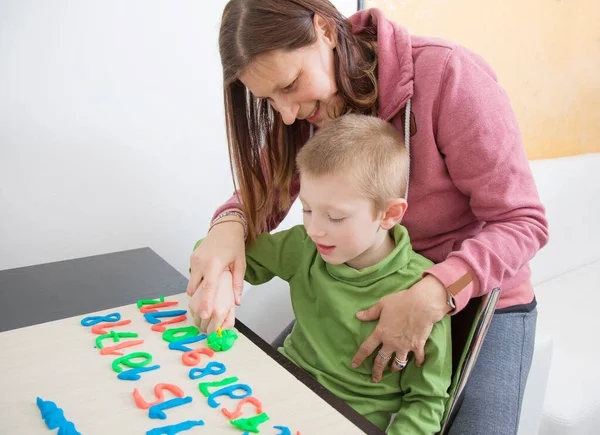 在验尸官检疫期间 一位母亲和她的小男孩在玩彩色模型粘土 — 图库照片
