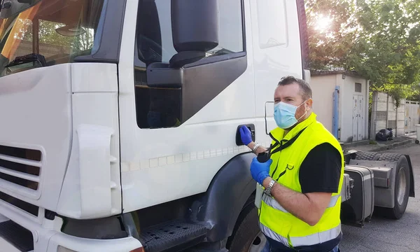 顔のマスクとコロナウイルスの保護手袋を持つトラック上の若い輸送者 — ストック写真