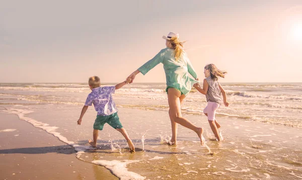 母亲和孩子们正在海滩上的海里玩耍 — 图库照片