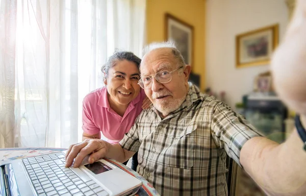Starszy Mężczyzna Opiekunką Robi Sobie Selfie Domu — Zdjęcie stockowe