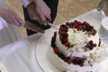 Yeni evliler pasta kesiyor.