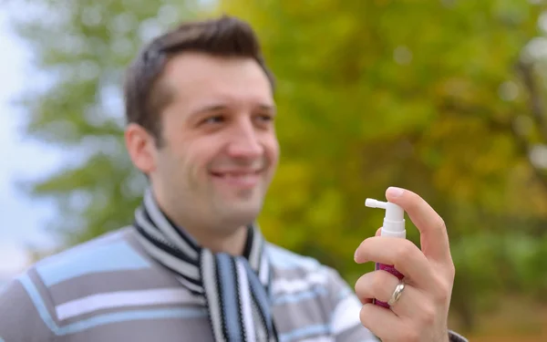 Ung man använder hals spray — Stockfoto