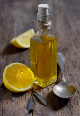 Olive oil and  lemon fruits on the wooden table clipart