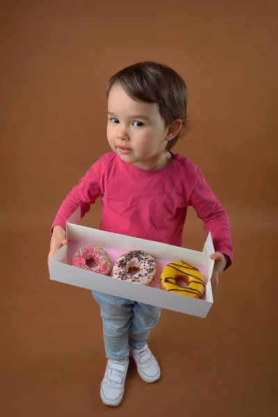 Little girl  with different donuts — Stock Photo, Image