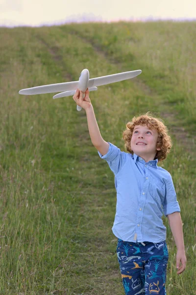 Kleine jongen houdt een houten vliegtuig-model — Stockfoto