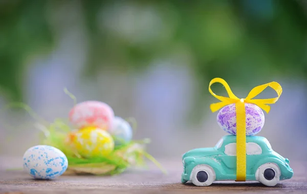 Carro de brinquedo transportando ovo de Páscoa — Fotografia de Stock