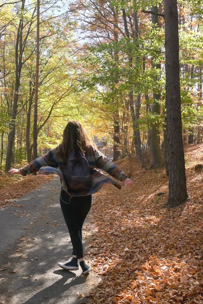 Νεαρό κορίτσι γυρίζει στο φθινόπωρο δάσος — Φωτογραφία Αρχείου