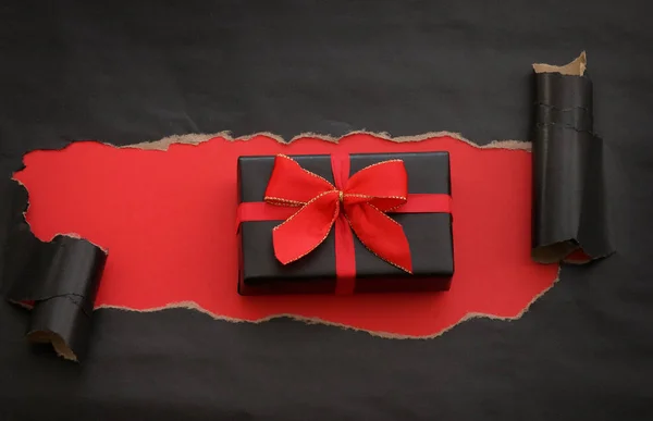 Carta strappata nera e un regalo — Foto Stock