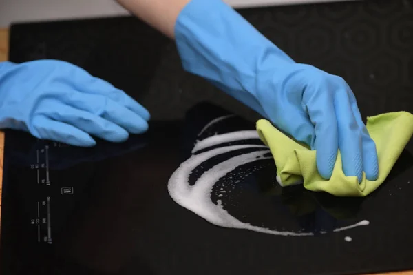 Женские руки чистят современную индукционную плиту — стоковое фото