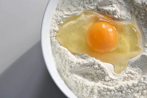 Σπασμένο αυγό στο αλεύρι, για την παρασκευή ψωμιού — Φωτογραφία Αρχείου
