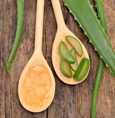 Aloe Vera ahşap masa ve kaşık dilimliyor Aloe jeliyle