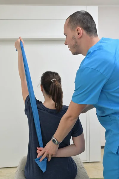 Молодой Физиотерапевт Мужчина Помогает Девочке Подростку Упражнениями Растяжку — стоковое фото