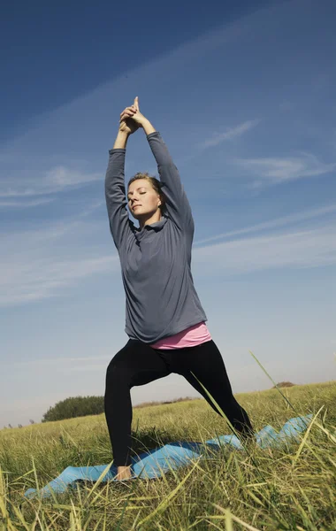 瑜伽姿势瑜伽在性质上的绿色草地上的女人 — 图库照片