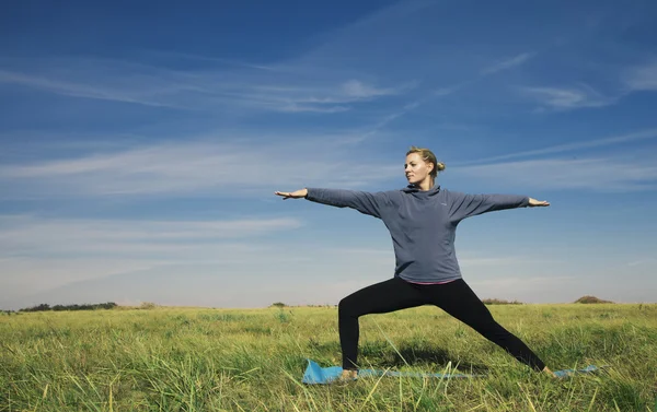 Yoga blonde schoonheid van de jonge vrouw op groen gras — Stockfoto