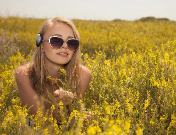 屋外音楽を楽しむヘッドフォンで若い金髪女性 — ストック写真