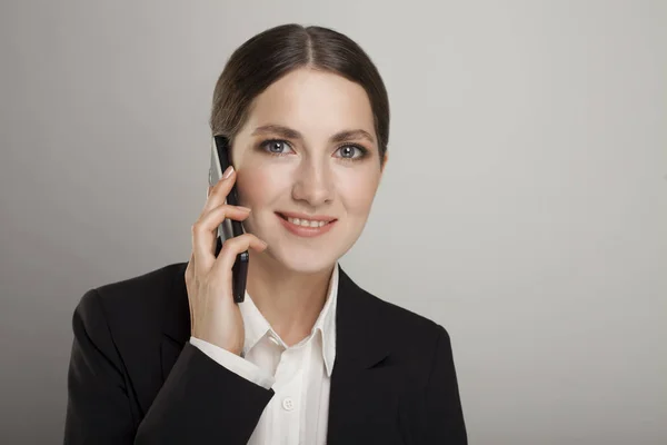 Femme d'affaires au téléphone isolée sur un fond gris — Photo