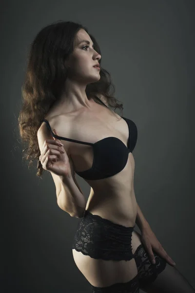 Sexy corps jeune femme en lingerie noire sur fond sombre . — Photo