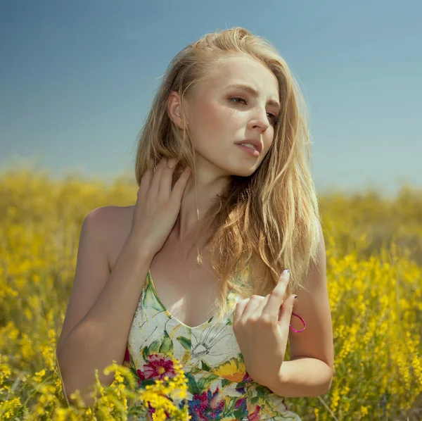 Vrouw op gele bloemen veld sluit portret — Stockfoto