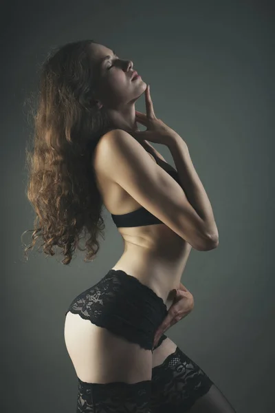 Woman in black lingerie on a dark bg studio shot — Stock Photo, Image