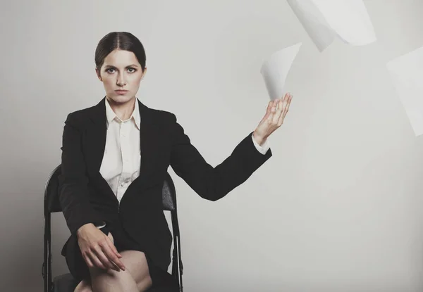 Mujer enojada elegantemente vestida arrojar una pila de papeles a la cam — Foto de Stock