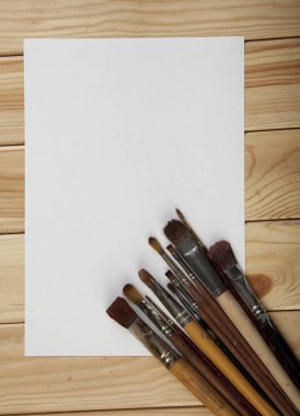  Fırçalar ve ahşap bir masa boş beyaz kağıda