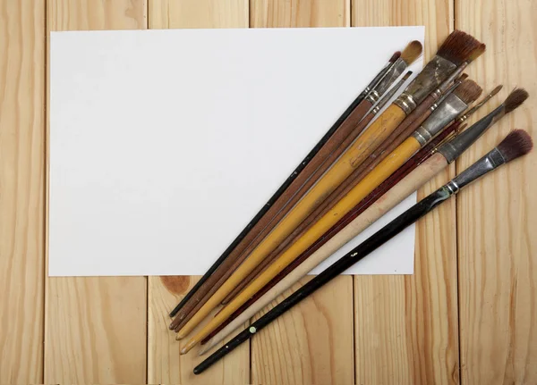  Fırçalar ve Beyaz Kağıt ahşap bir masa üzerinde