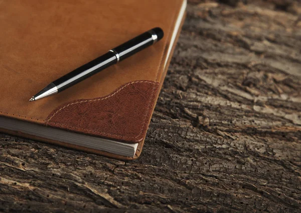 Rohové deník a pera na staré dřevěné pozadí — Stock fotografie
