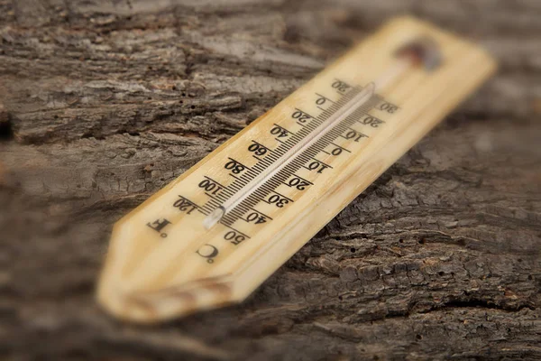 Termometr na stare zdjęcie drewniane tła efekt rozmycia — Zdjęcie stockowe