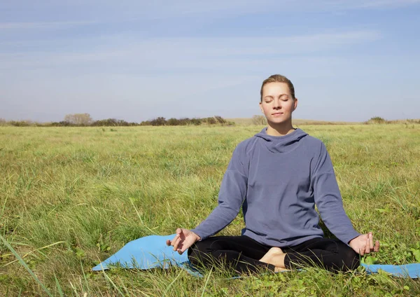 Ung kvinna på ett natur yoga foto — Stockfoto