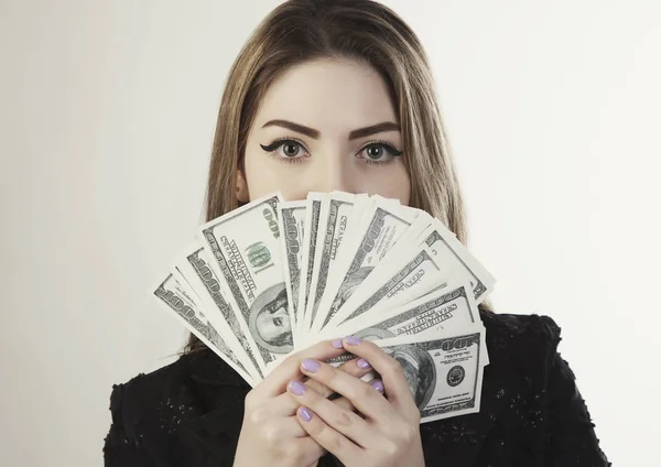 Женщина с деньгами рядом с портретом — стоковое фото