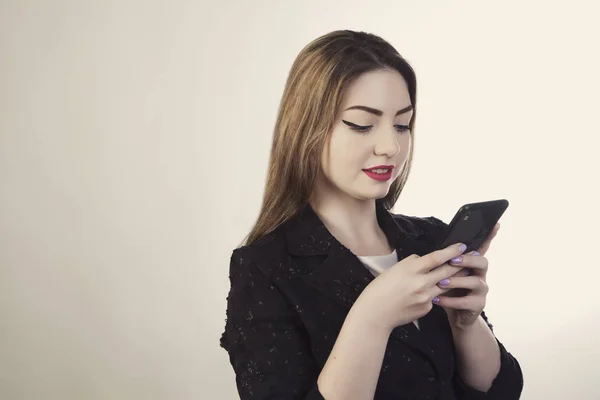 Vrouw zoekt in de mobiele telefoon en glimlachte — Stockfoto