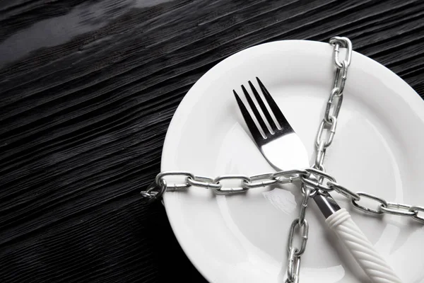 Ahşap arka plan siyah plaka çatal zinciri diyet kavramı — Stok fotoğraf