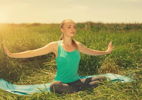 Sarışın genç kadın kapalı gözler ile doğa üzerinde meditasyon — Stok fotoğraf