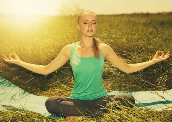 Uygun sarışın genç kadın gözleri kapalı doğa üzerinde meditasyon — Stok fotoğraf