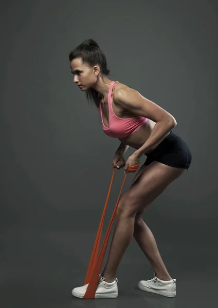 Jonge sport vrouw met rubber studio opname — Stockfoto