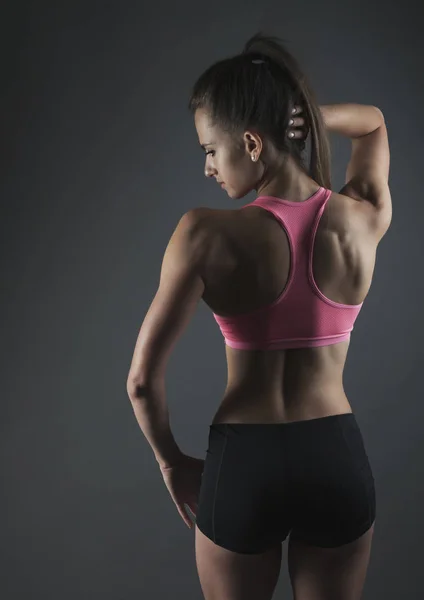 Volver deporte mujer en oscuro bg studio shot — Foto de Stock