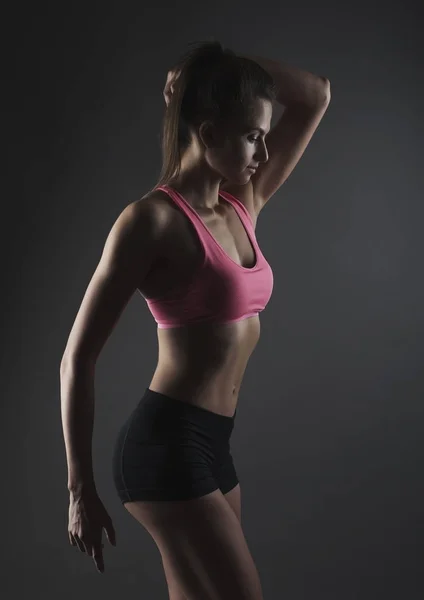 Mulher retrato jovem esporte no escuro bg estúdio — Fotografia de Stock