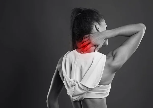 Vrouw terug sport rode gebied pijn studio op donkere dg foto — Stockfoto